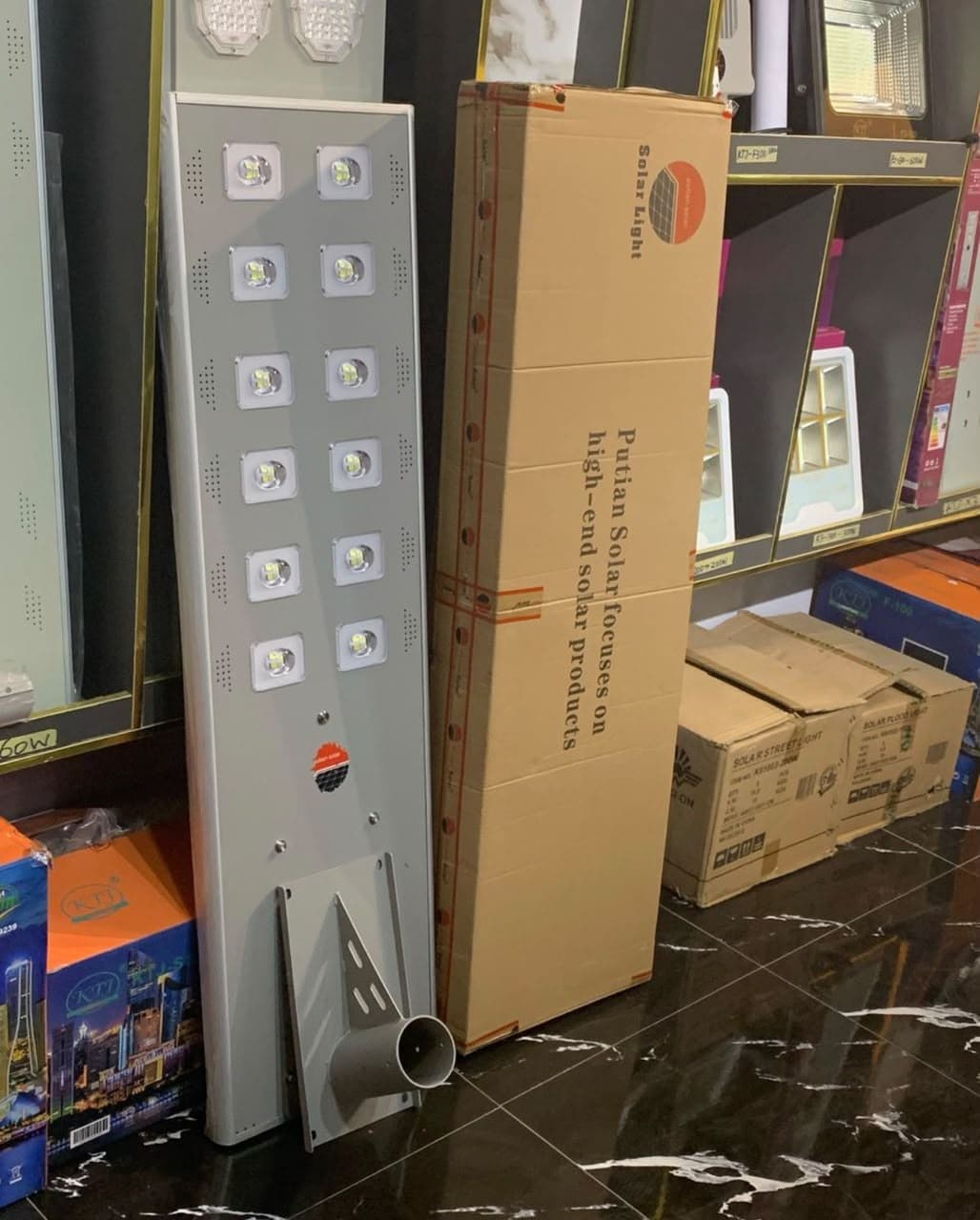 Putian 100W all-in-one solar street light beside its carton
